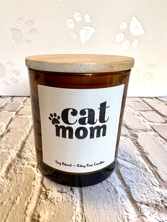 Candle with 'cat mom' label on a textured surface
